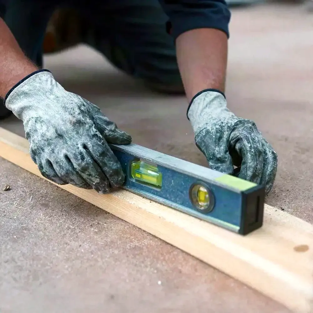 Tradesperson checking a level against a timber frame