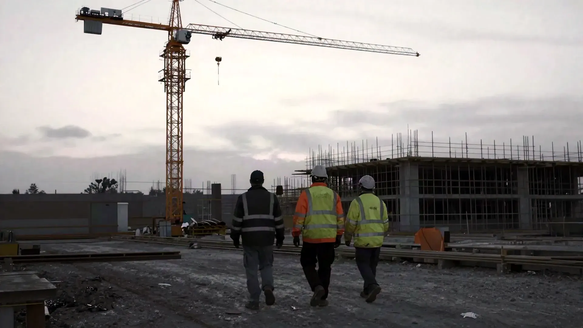 Buildcore crew walking a job site at dusk